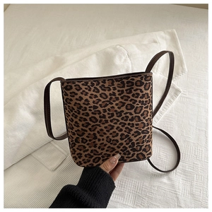 Detailed macro view of the leopard print faux fur texture and brown piping on the square bag