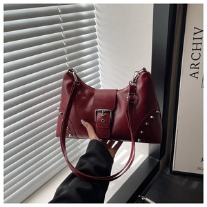 Detail of burgundy PU leather tote bag with silver studs and polished metal buckle