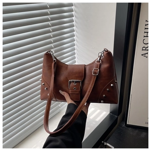 Close-up of vintage brown PU leather tote bag with silver rivets and metal buckle detail