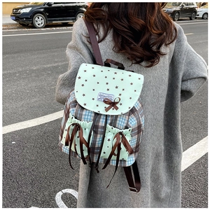 Detailed shot of retro plaid backpack with lace bow and star print side pockets