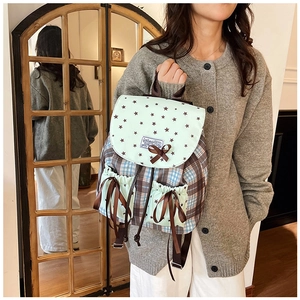 Detail of vintage preppy backpack with lace bow and star pattern on mint green flap