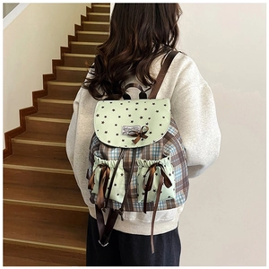 Detail view of vintage plaid backpack with lace bows and star pattern flap for women
