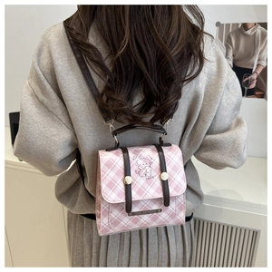 Detail eines rosa karierten Mini-Rucksacks mit Cartoon-Hund Illustration und Ledergriff