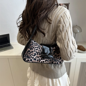 Retro leopard print underarm bag with glossy black bow accent and patent leather details
