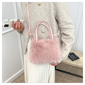 Vue détaillée de la texture en fausse fourrure rose et de la poignée en cuir du sac seau