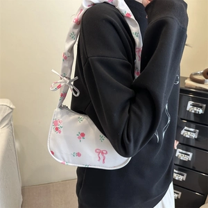 Sac sous le bras blanc avec motifs roses et nœuds mignons présenté dans un cadre de vie