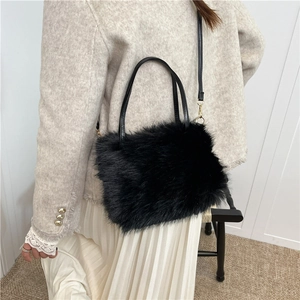 Sac seau noir en fausse fourrure avec poignées en cuir et bandoulière à crochets dorés