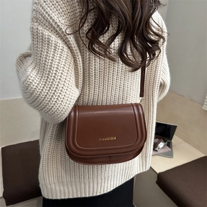 Chic brown saddle crossbody bag with gold fashion lettering and fine shoulder strap