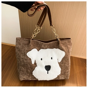 Detail of brown corduroy tote bag featuring a 3D plush puppy patch and gold chain strap