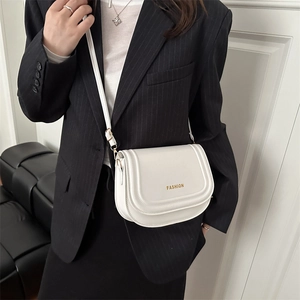 Chic white flap crossbody bag with fashion lettering on a model in a striped blazer
