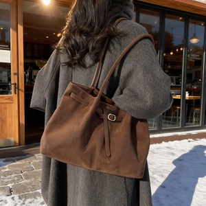 Grand sac fourre-tout en daim marron foncé pour femme dans un décor d'hiver chic