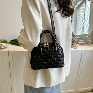 Elegant black quilted shell handbag with gold zipper and adjustable crossbody strap