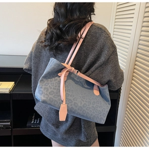 Detail of blue leopard print tote bag with contrasting pink leather shoulder straps