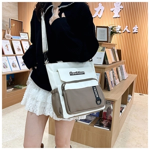 Detail of canvas messenger bag featuring fashion embroidery and side storage pockets