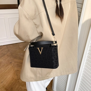 Sac bandoulière noir chic avec motif léopard et logo V doré sur la bandoulière