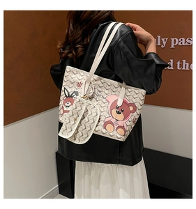 Détail d'un grand sac fourre-tout beige avec motif d'ours et une petite pochette assortie