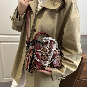 Borsa a tracolla leopardata con cinturini rosso-marroni e fiocco di pizzo indossata da modella