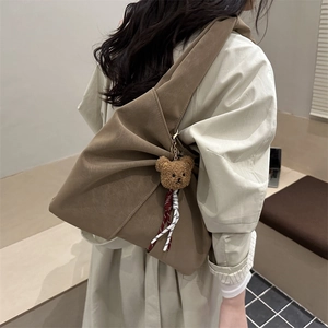 Minimalist brown textured leather shoulder bag with a cute teddy bear charm detail