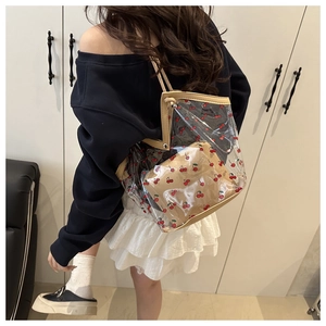 Détail du sac cabas transparent en PVC à imprimé cerise avec pochette intérieure beige