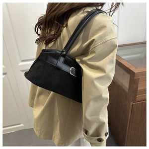 Détail d'un sac à bandoulière en daim noir avec sangle en cuir et boucle en métal argent