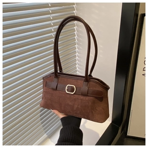 Détail du sac bandoulière vintage en daim marron avec texture mate et boucle dorée