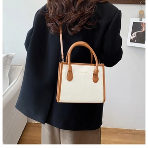Model view showing the crossbody carry of this beige and brown textured shoulder bag