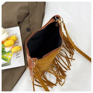Close-up of brown suede crossbody bag with long fringes and gold metal chain hardware