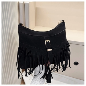 Close-up of black faux suede shoulder bag with gold buckle and long fringe detailing