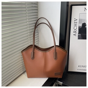 Close-up of brown litchi pattern PU leather tote bag with Fashion & Bags brand patch