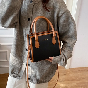 Minimalist bicolor tote bag in black pebbled leather and brown straps for commuters