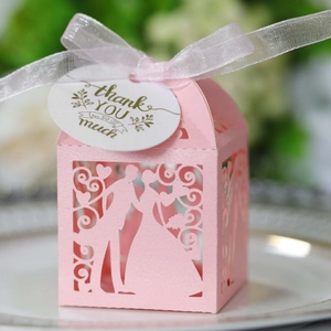 Scatola per bomboniere rosa traforata con silhouette di sposi e nastro in organza bianca