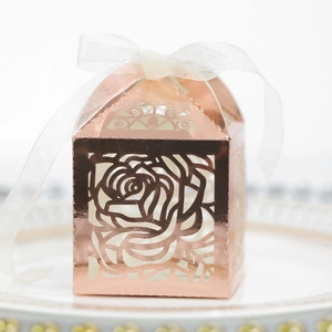 Laser cut rose gold wedding favor box with floral patterns and a white ribbon bow