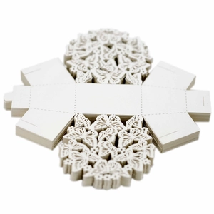 Stack of white laser-cut wedding candy boxes with delicate hollow butterfly patterns