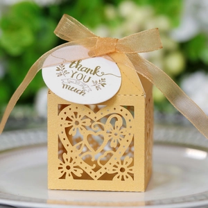 Elegant gold hollow heart favor box with floral patterns and a thank you tag for weddings