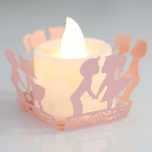 Pink laser-cut paper candle wrap with couple silhouette and warm white LED tea light