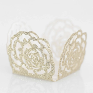 Sparkling champagne gold glitter cupcake wrappers with laser-cut rose patterns