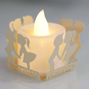 Warm LED tea light with intricate white paper cutout silhouettes for party decor