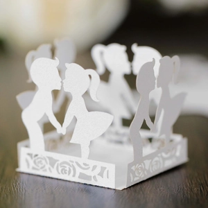 White laser-cut paper cake decoration with romantic boy and girl silhouette and roses