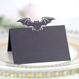 Halloween black bat wing place card with spiderweb hollow design on a ceramic plate