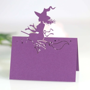 Laser-cut purple Halloween place card with witch on broomstick silhouette and stars