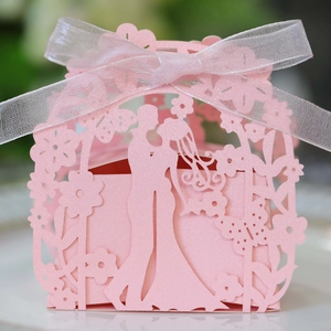 Pink laser-cut wedding candy box with ribbon and romantic bride and groom silhouette