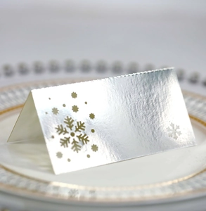 Silver hollow snowflake place card for Christmas wedding table setting on ceramic plate