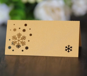 Elegant laser-cut snowflake place card in pearl gold finish for Christmas table decor