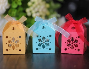 Cajas de caramelos caladas con copos de nieve rosa y azul con lazos para fiestas de Navidad
