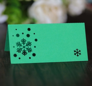 Green foldable Christmas place card with delicate black snowflake and blank space