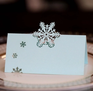 Light blue pearlescent place card with snowflake cutout for elegant winter table setting
