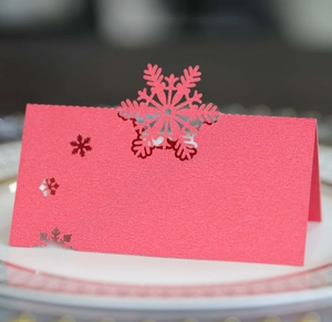 Red laser-cut snowflake place card in pearlescent paper for festive Christmas table decor