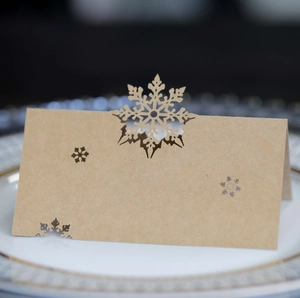 Brown kraft paper snowflake place card with laser-cut design for Christmas table settings