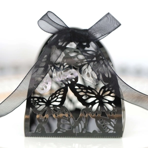 Elegant laser cut black butterfly favor box with black organza ribbon on white background