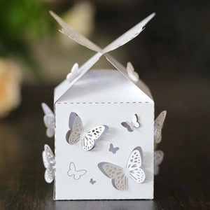 Elegante scatola bianca con farfalla tagliata al laser su tavolo in legno scuro